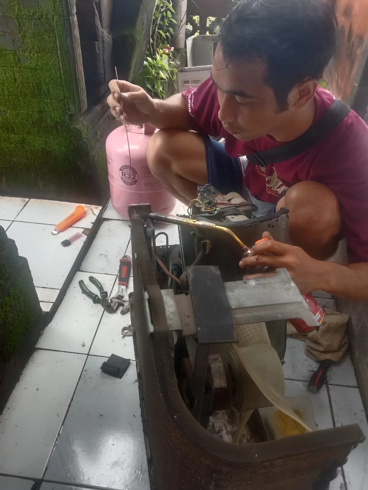Teknisi melakukan service dan pengecekan sparepart AC outdoor